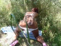 A dirty crossdresser is masturbating outside while prodding a restricted arse hole with a sex object.